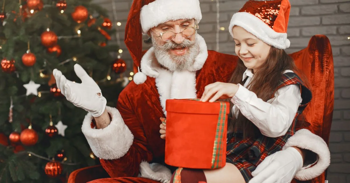 Un joyeux Père Noël partage un cadeau avec un enfant ravi dans un cadre festif.