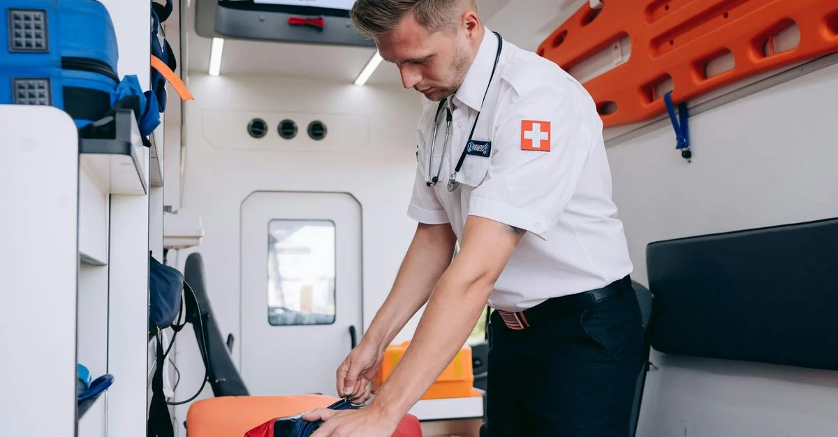Un infirmier sapeur en uniforme organise le matériel médical à l'intérieur d'une ambulance, se préparant pour les services d'urgence.