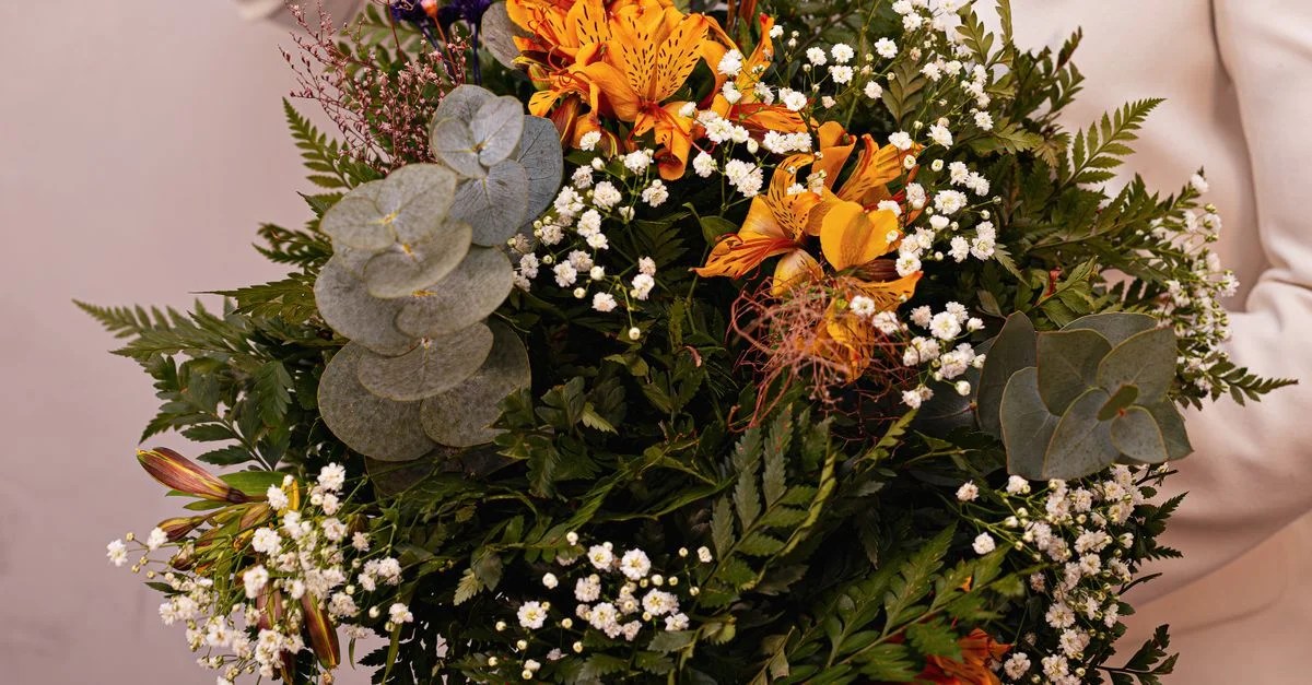 Un bouquet luxuriant composé de lys orange et d'eucalyptus, mettant en valeur des couleurs vibrantes et une beauté naturelle.