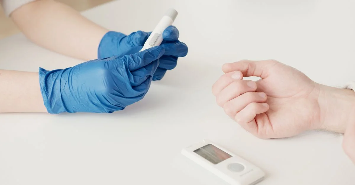 Un professionnel de la santé utilise un glucomètre pour vérifier les niveaux de sucre dans le sang dans un environnement intérieur.