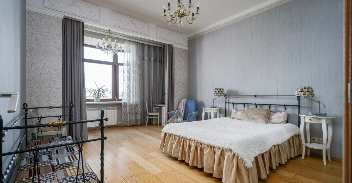 Chambre luxueuse avec un grand lustre, des meubles élégants et des éléments de design d'intérieur classiques.