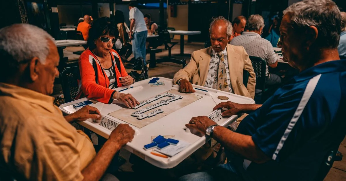 Groupe de seniors engagés dans une partie de Mahjong en extérieur à Miami, Floride.