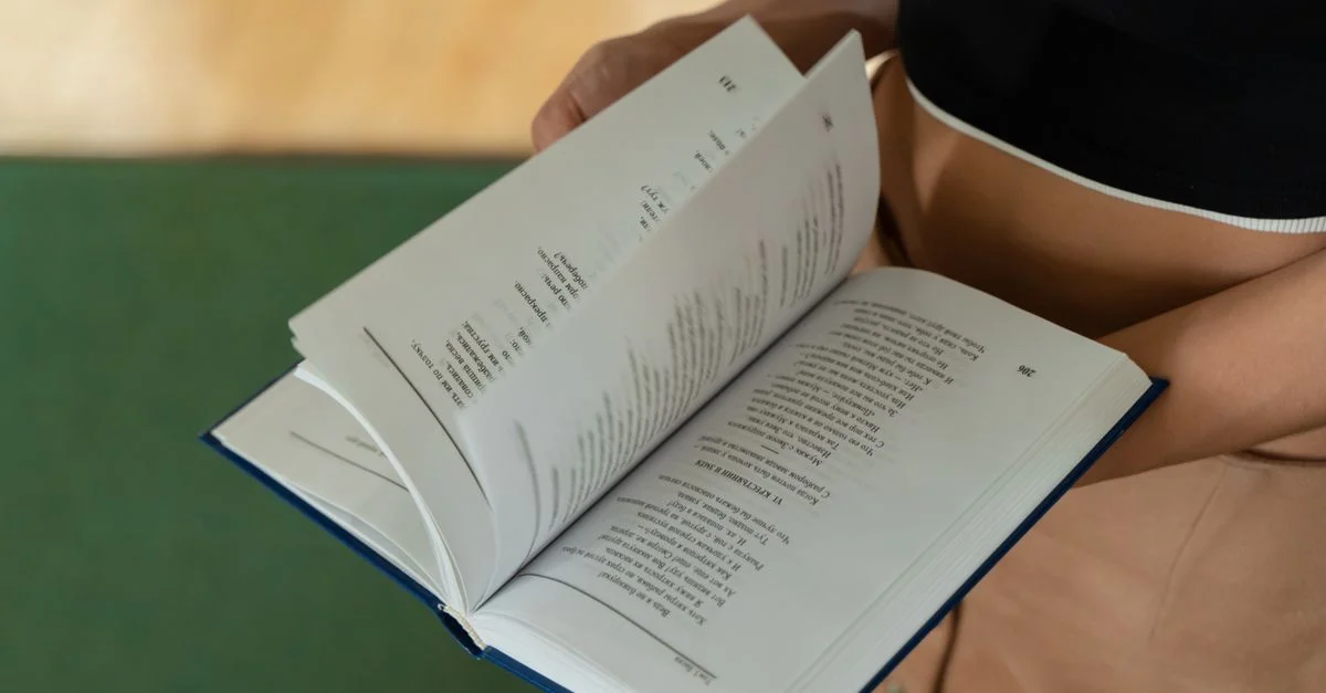 Une vue détaillée d'une personne tenant un livre ouvert, montrant ses pages.