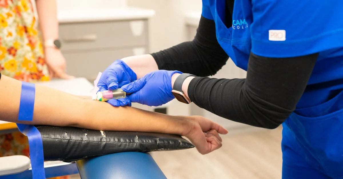 Une infirmière effectue une prise de sang avec des gants bleus dans un environnement de clinique médicale.