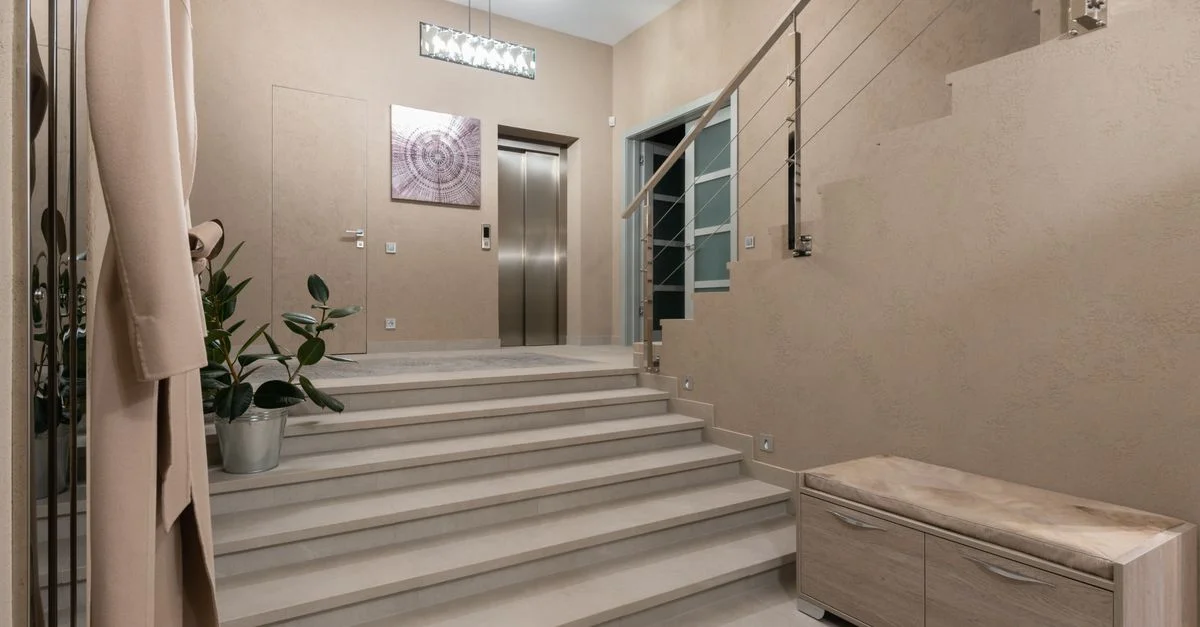 Hall d'appartement élégant et spacieux avec design contemporain, escalier et ascenseur.
