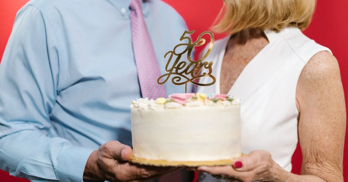 Un couple célébrant leur 50e anniversaire avec un gâteau décoratif, symbolisant un lien durable.