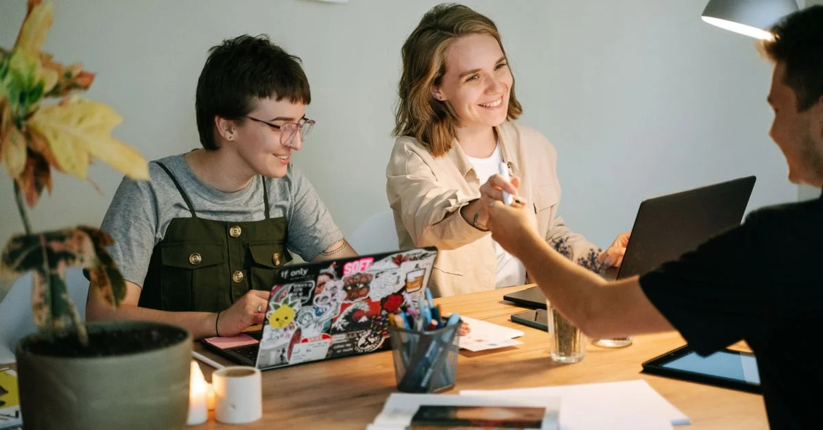 Un groupe de jeunes professionnels collaborant dans un bureau bien éclairé, se concentrant sur un projet.