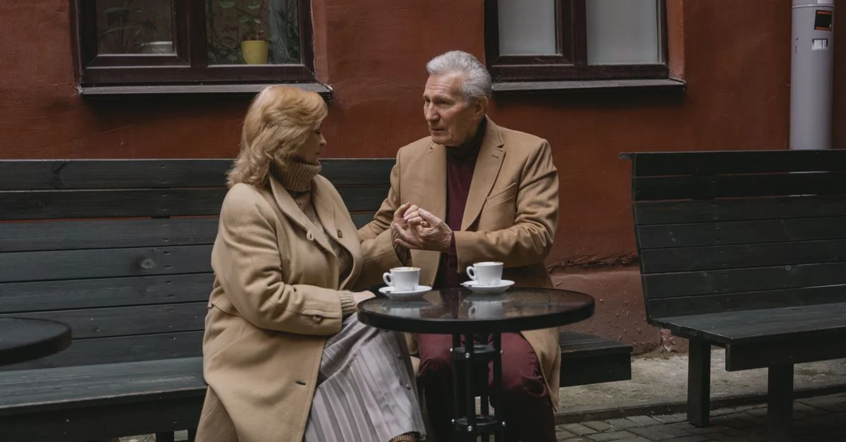 Un couple âgé profite d'une conversation autour d'un café dans un café en plein air.