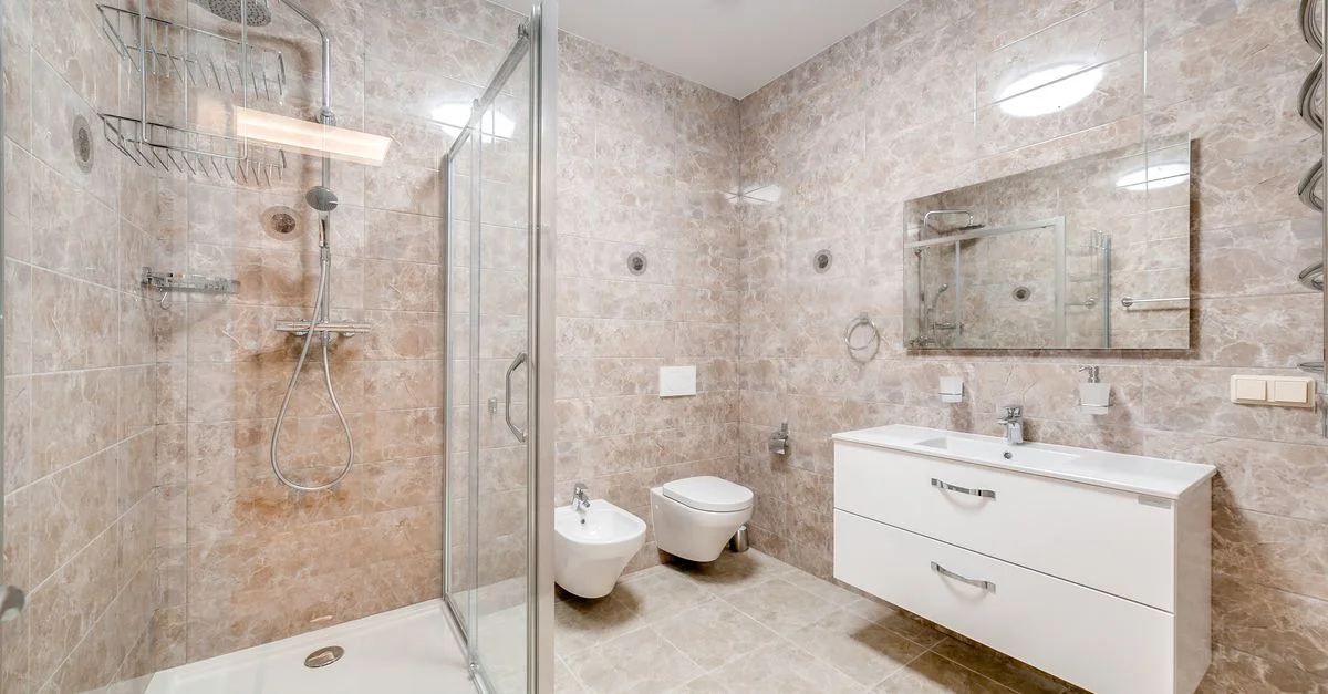 Salle de bain contemporaine avec douche en verre et équipements élégants dans un design minimaliste.