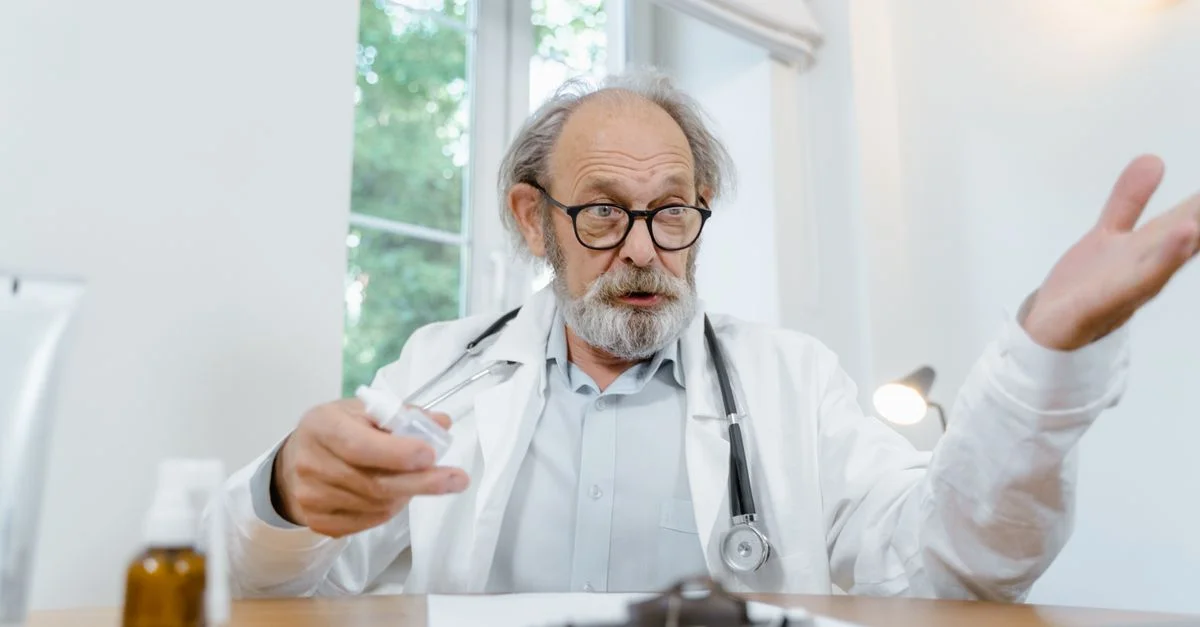 Médecin senior en discussion tenant une seringue dans un cabinet médical, véhiculant expertise et soin.