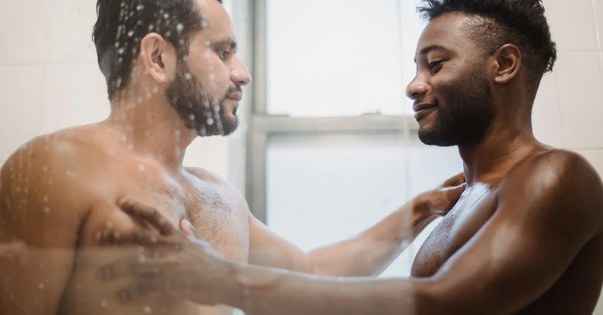 Un couple aimant partage un moment tendre sous la douche, mettant en valeur leur intimité et leur connexion.