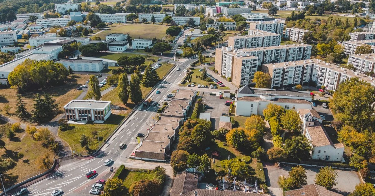 Vue aérienne des rues suburbaines et des bâtiments à Bordeaux, France, mettant en valeur l'aménagement urbain.