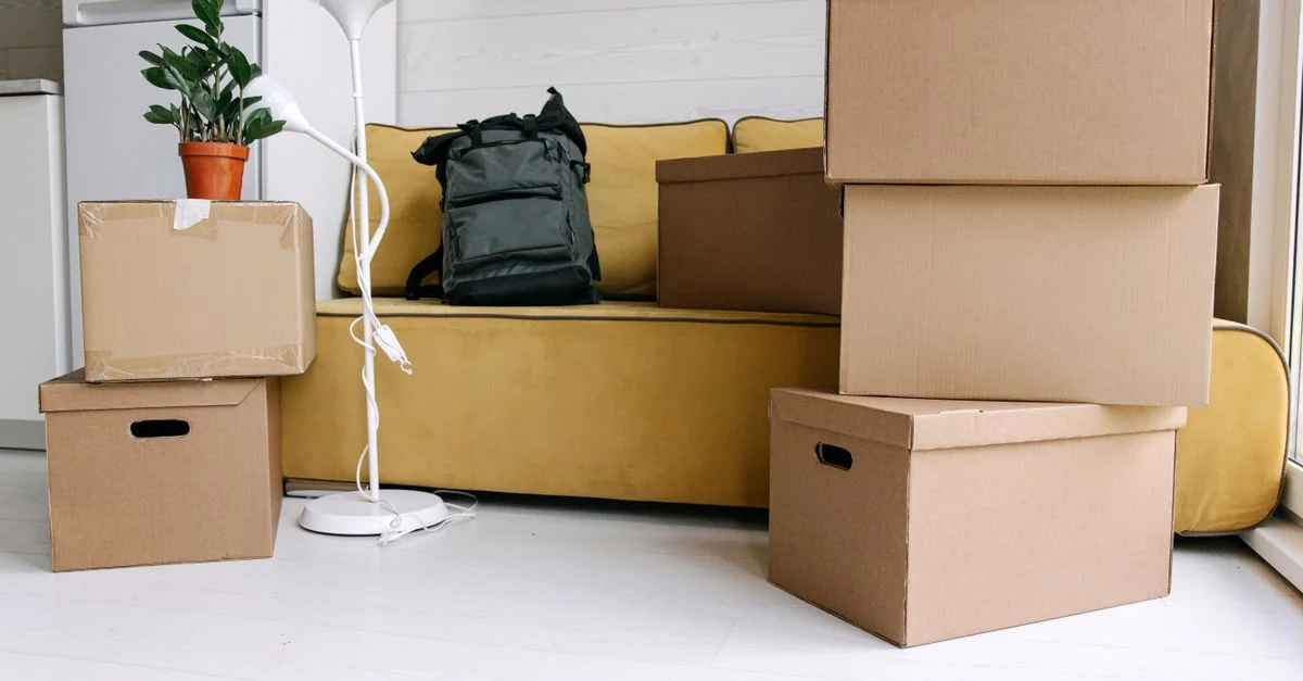 Des boîtes en carton et un sac à dos dans un salon confortable signifient l'excitation du jour du déménagement.