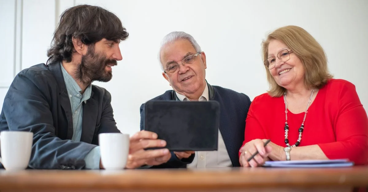Couple âgé en réunion avec un consultant, explorant des options financières ou d'assurance.