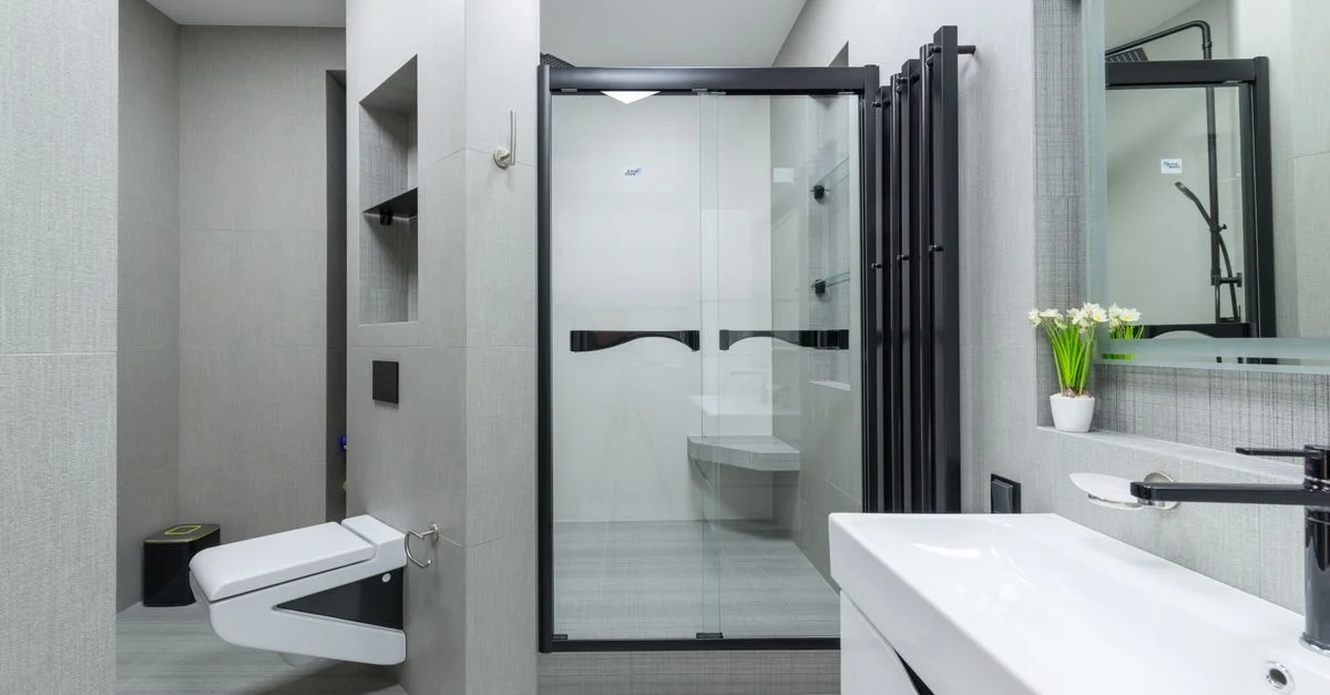 Salle de bain contemporaine spacieuse au design élégant, comprenant une douche en verre et des accessoires modernes.