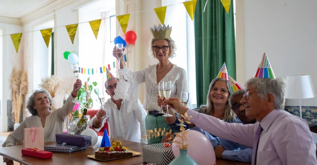 Des seniors profitant d'une fête d'anniversaire festive avec des décorations, trinquant et recevant des cadeaux.